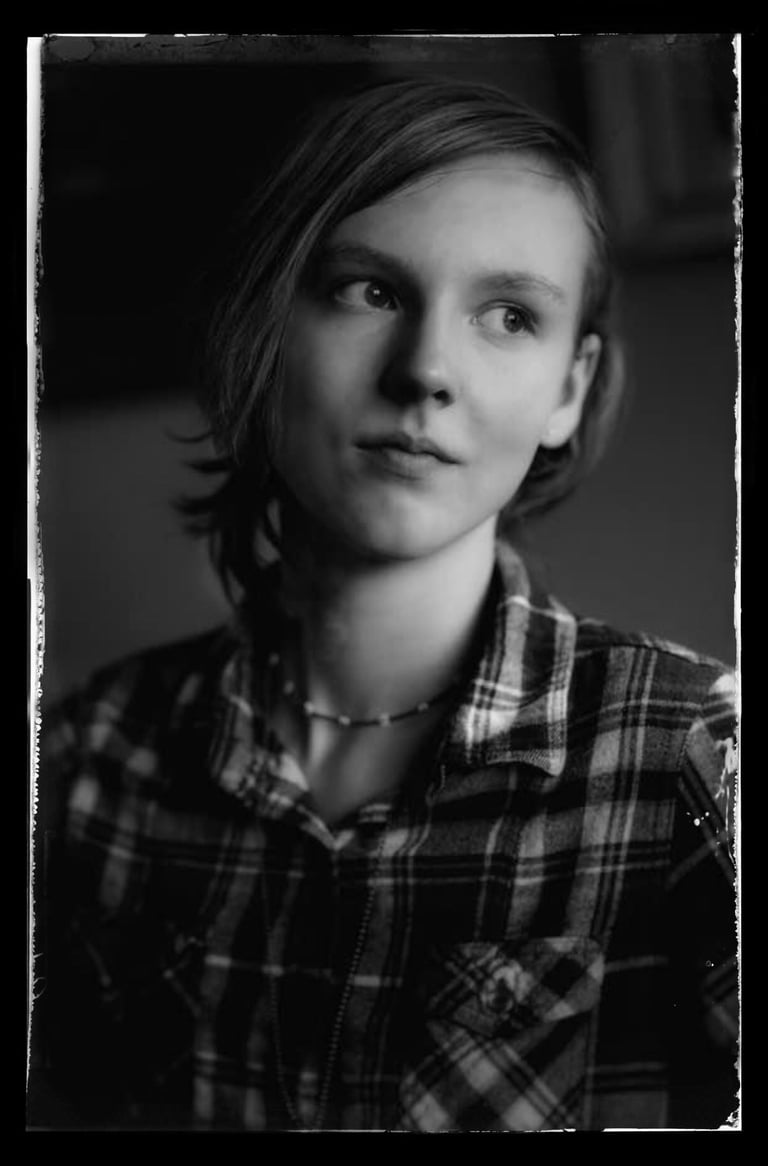 a young woman in a plaid shirt and smiling
