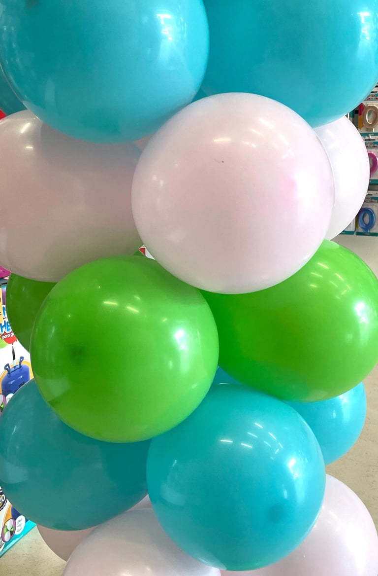 Columna de globos en colores de verano, blancos, azules y verdes.