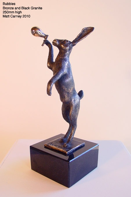 a statue of a rabbit blowing a balloon