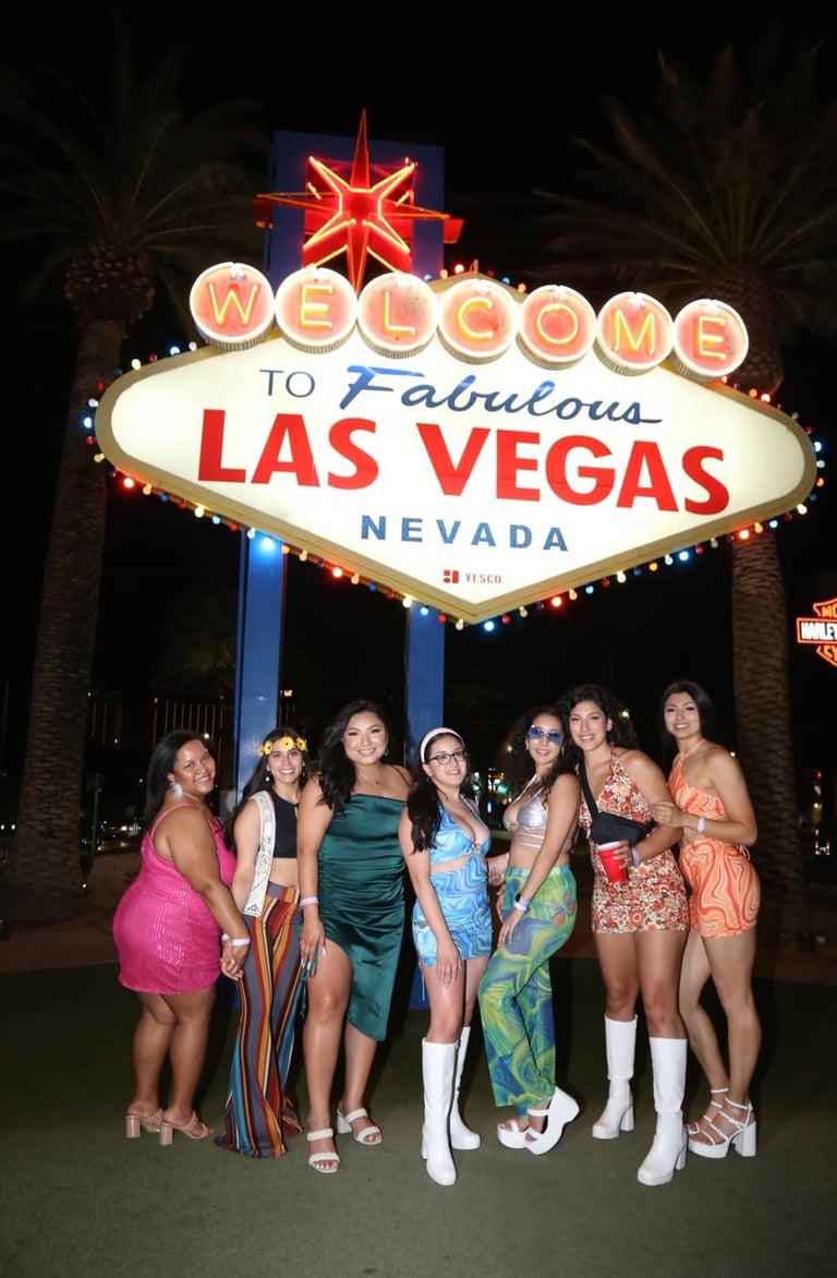 Party Bus Booking Las Vegas private service group photo at the Welcome to Las Vegas sign at night