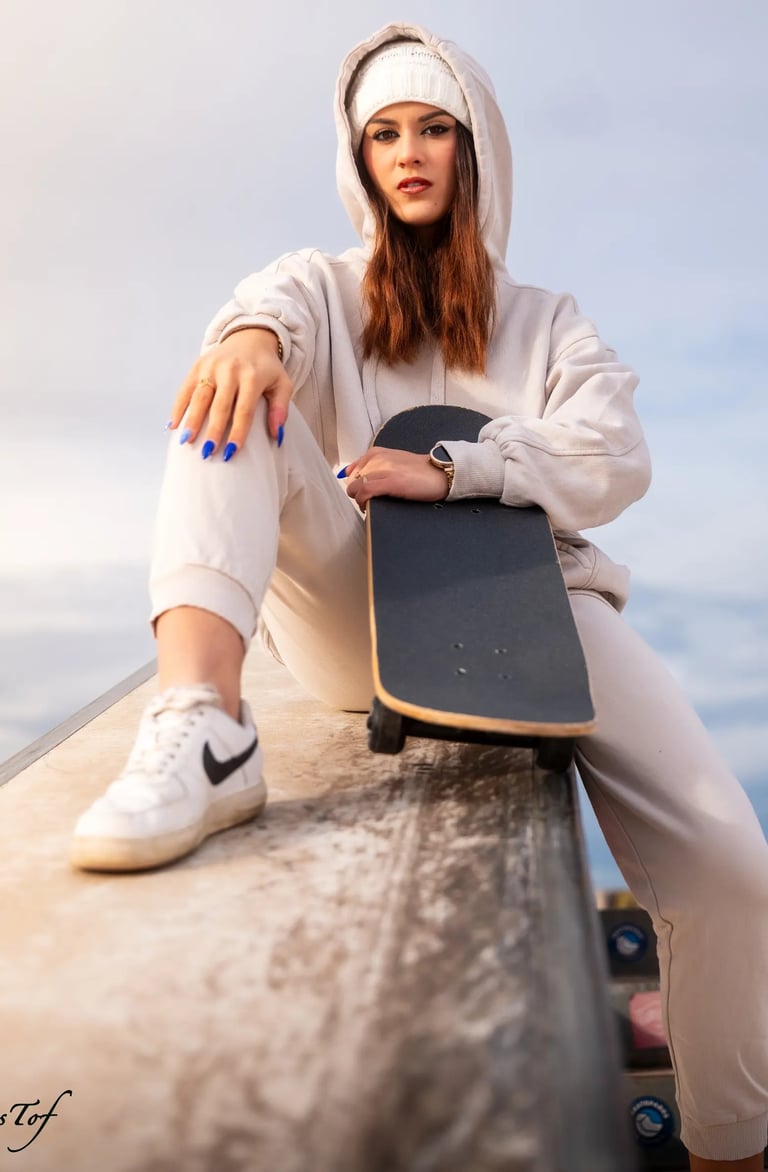 Photo d'un jeune femme en tenue de sport assise avec son skateboard au skatepark de Perpignan 66.