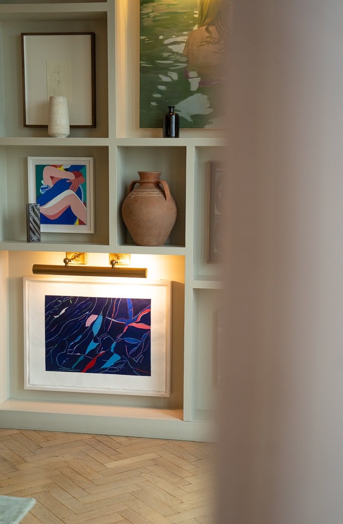 multiple art collection on the wall with vases
