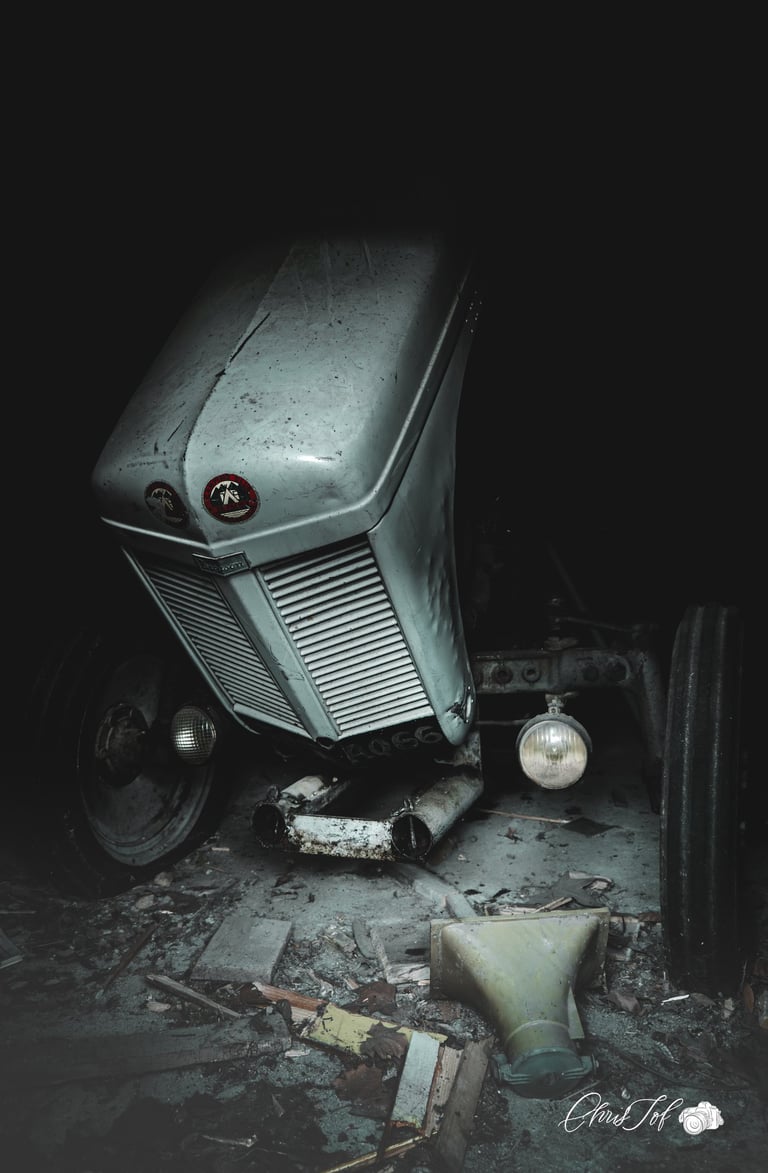 photographie urbex dans une grange abandonnée et sombre avec un tracteur , couleur naturel , 66