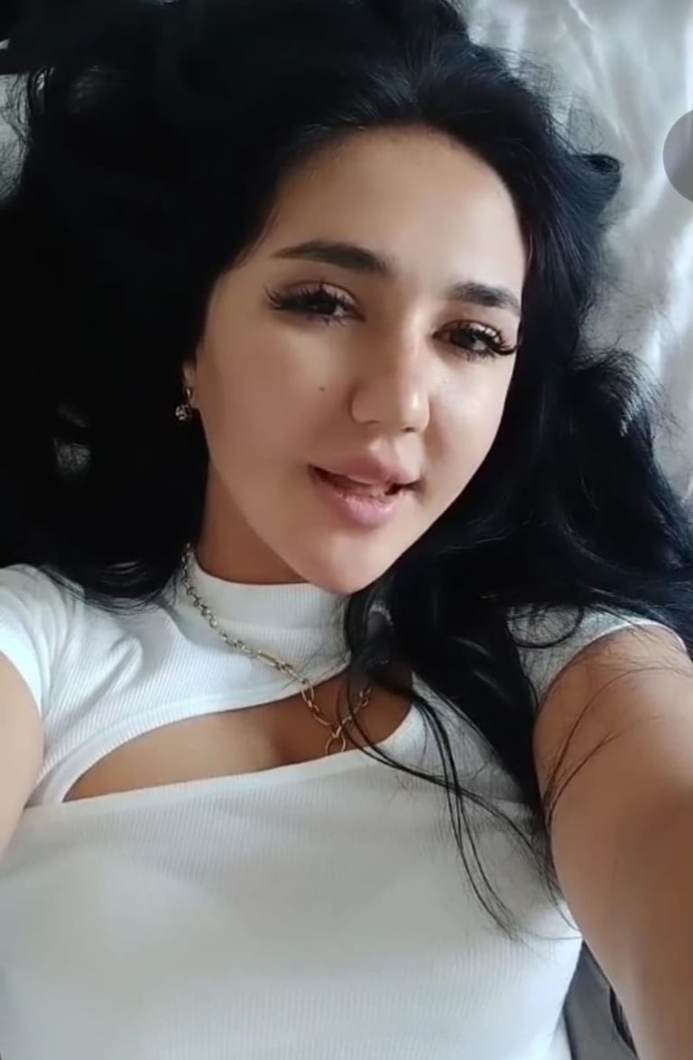 lady therapist lying on bed with white dress taking a selfie