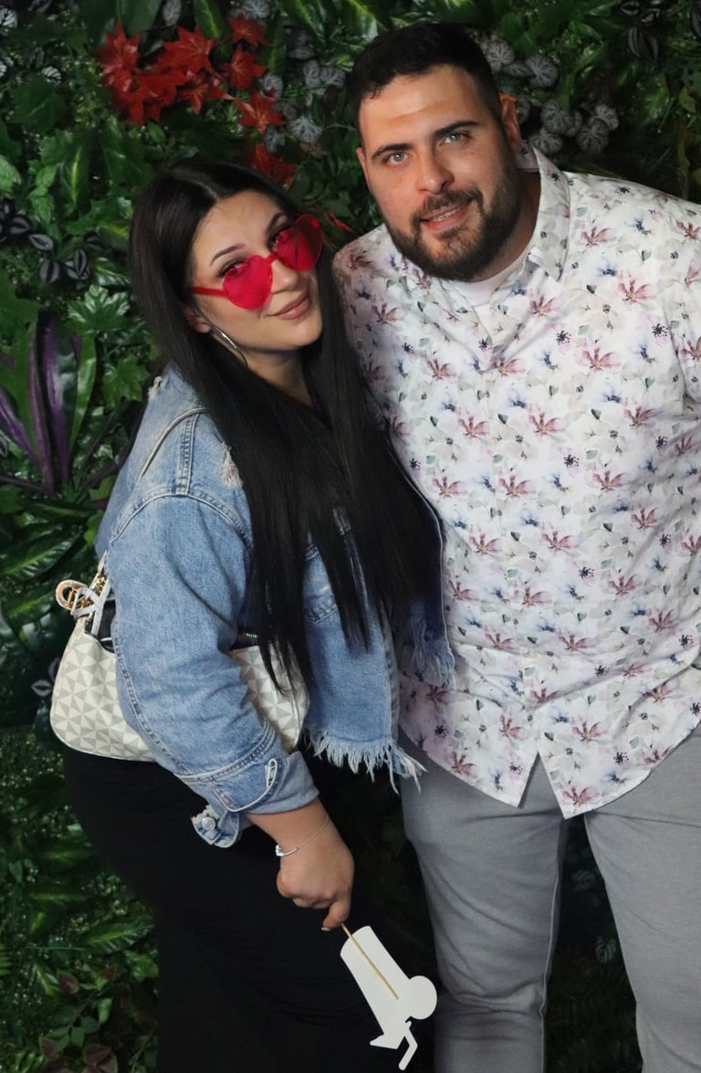 Ein Mann und eine Frau bedienen die Spiegel Fotobox zur Miete auf einem Geburtstag in Heilbronn