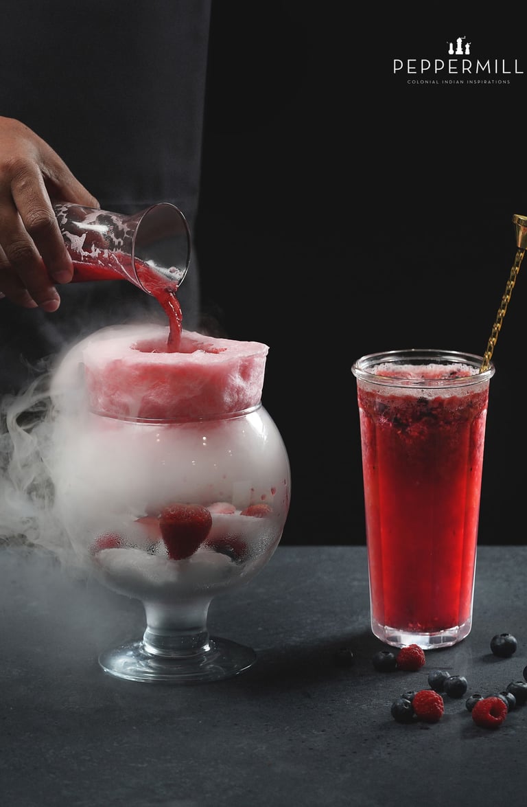 a person pouring a drink into a glass of ice cream