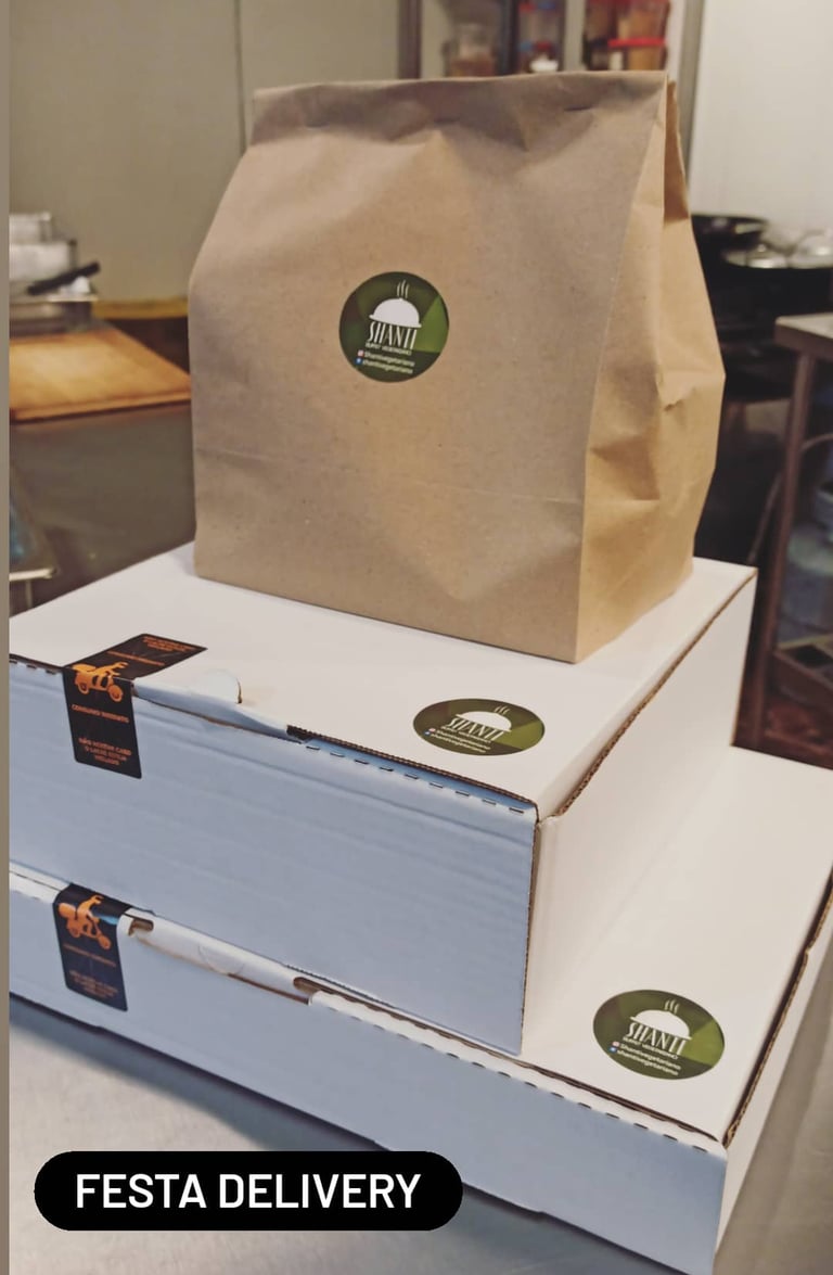 a box of pizzas with a brown paper bag