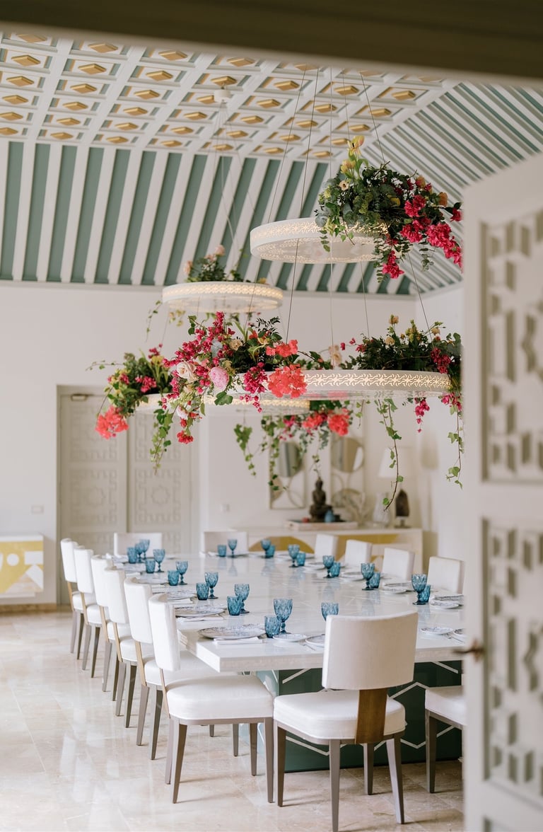 Dining room at Villa El Rincon featuring ornate ceilings with hanging lights and floral decorations for a destination wedding