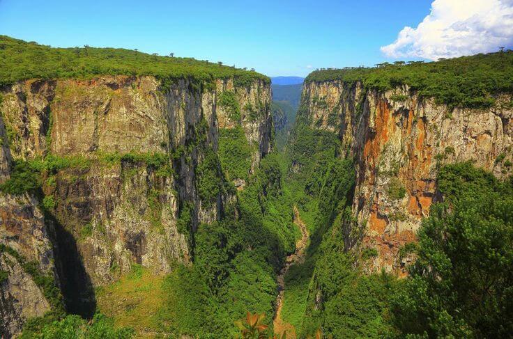 a view of a canyon with a waterfall and a waterfall