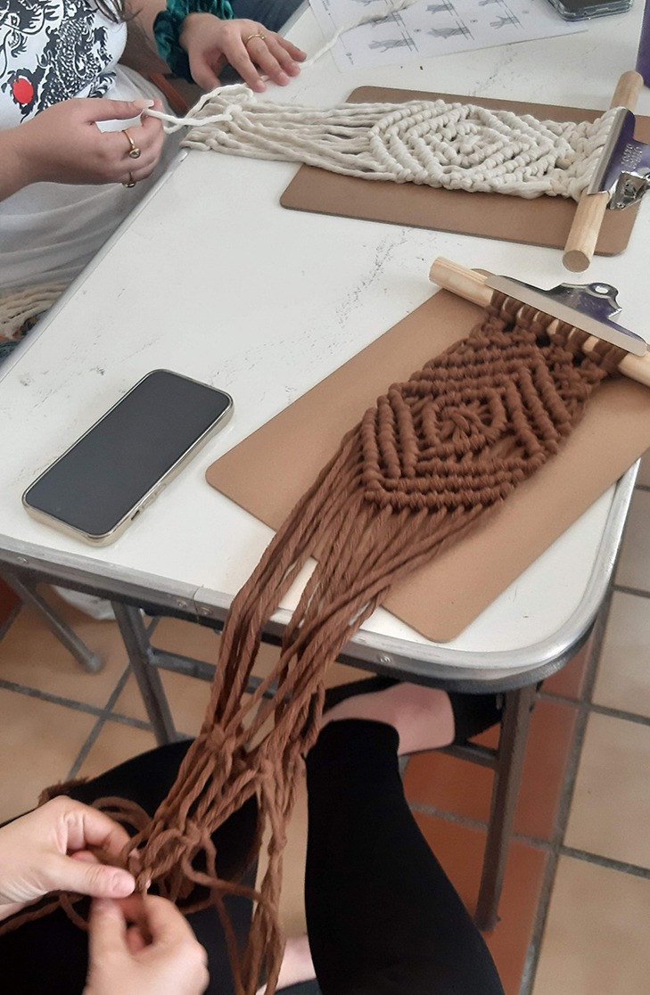 personas tejiendo a mano cordones con la técnica de macramé en un taller intermedio