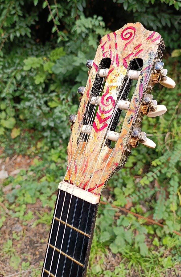 détail de Suun, une peinture sur guitare aux couleurs vives et contrastées - tête de la guitare
