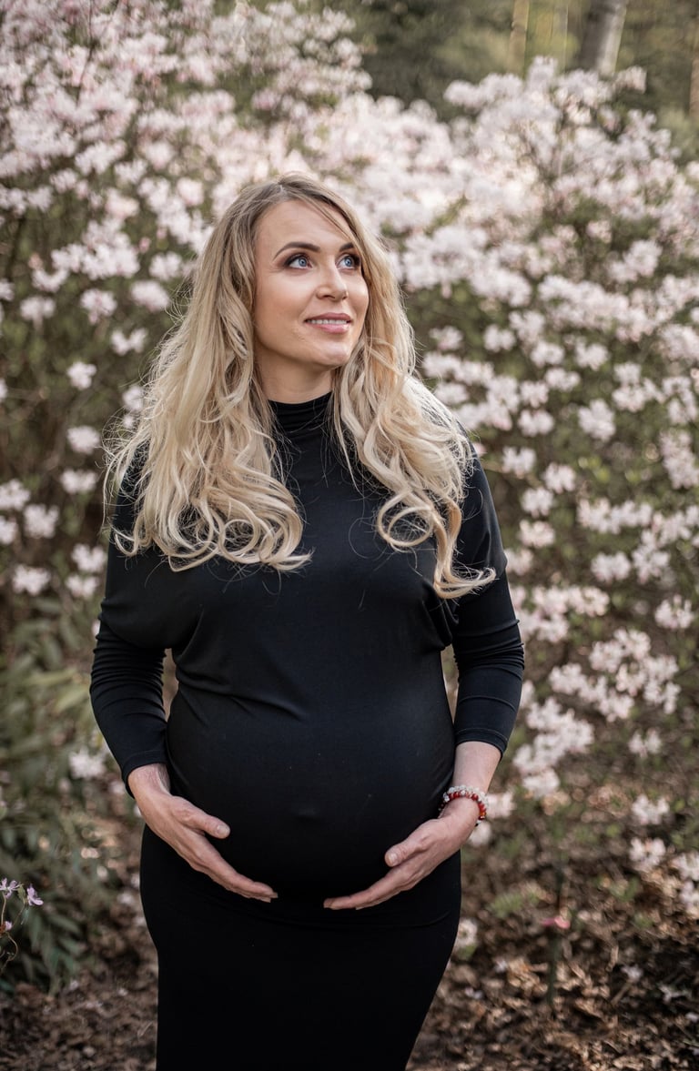 Nėštukės fotosesija prie gėlių su juoda aptempta suknele