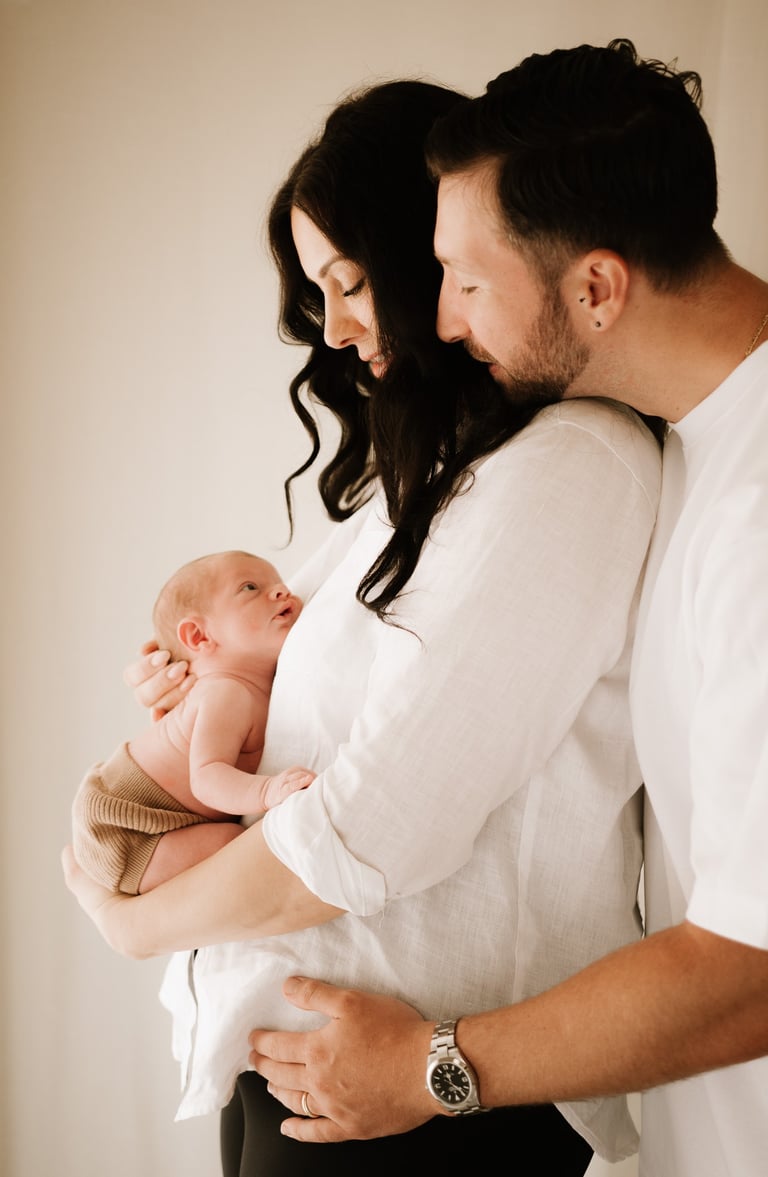 couple holding newborn baby where baby bump was, in studio Adelaide Hills 