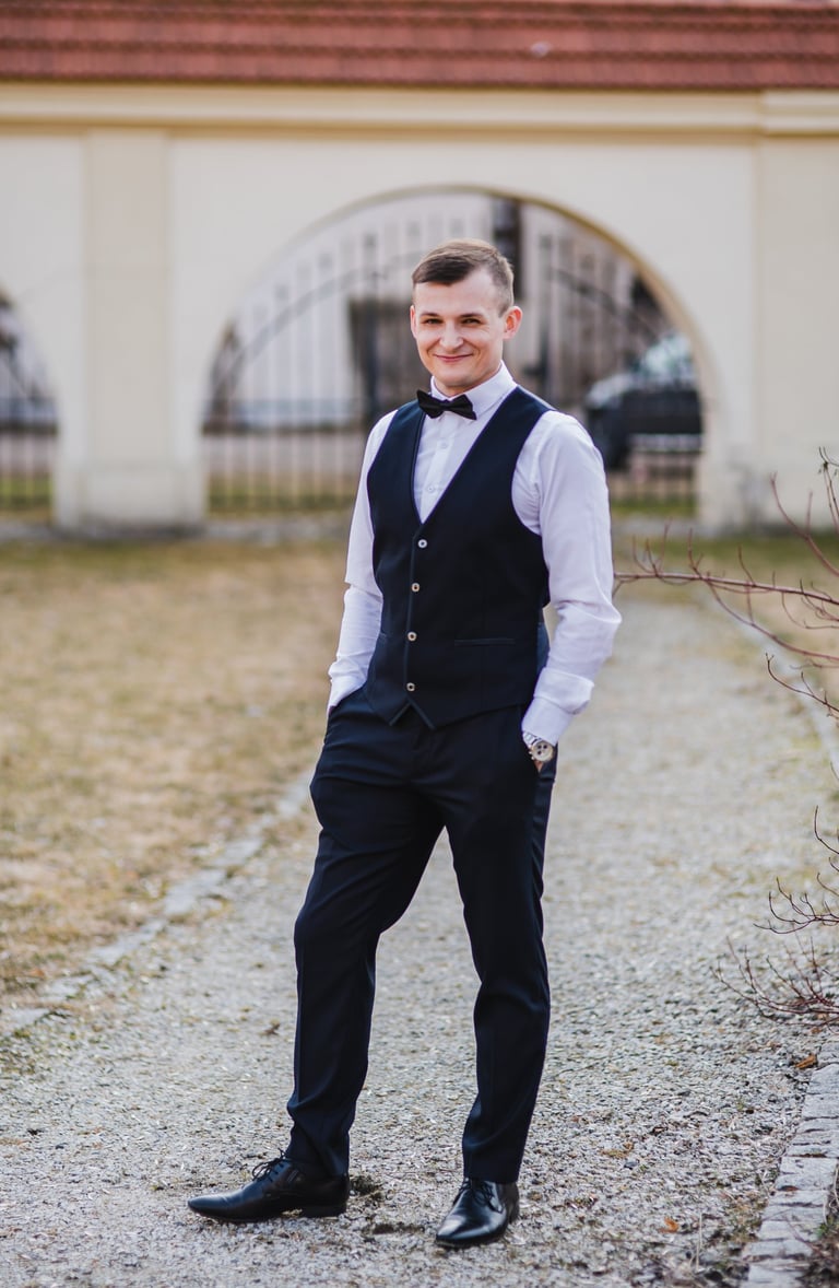 Jaunikis stovi atsipalaidavęs, su šventiniai drabužiais