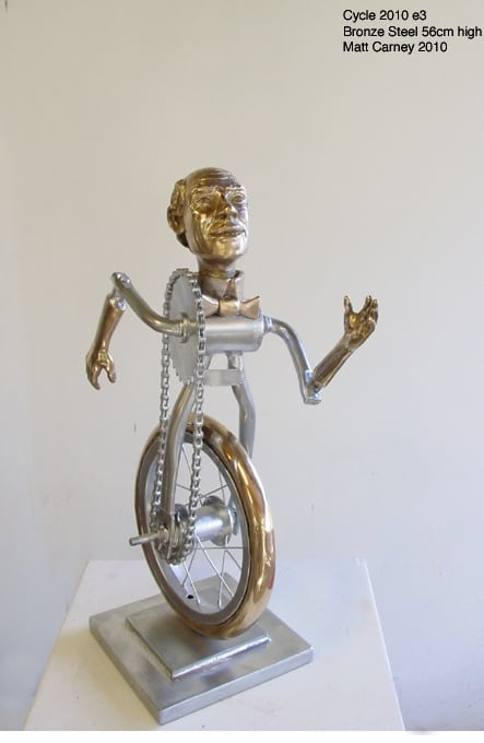 a metal sculpture of a man as a bicycle