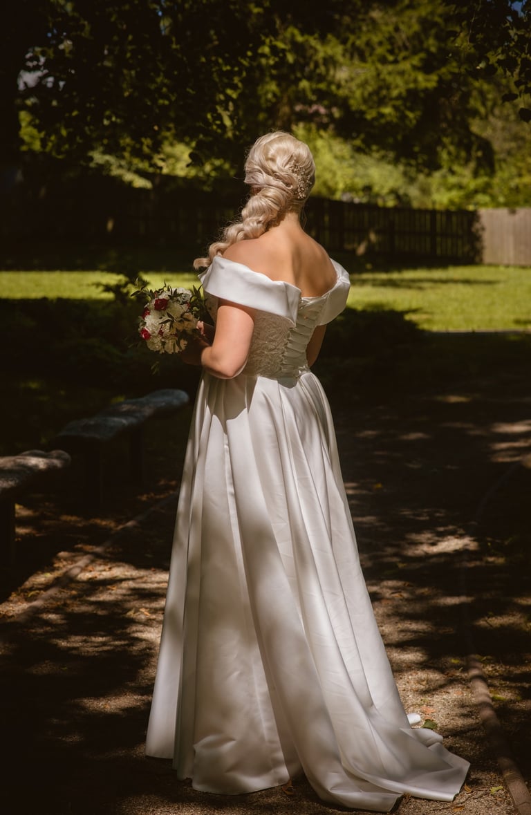 a woman in a white dress standing in a park