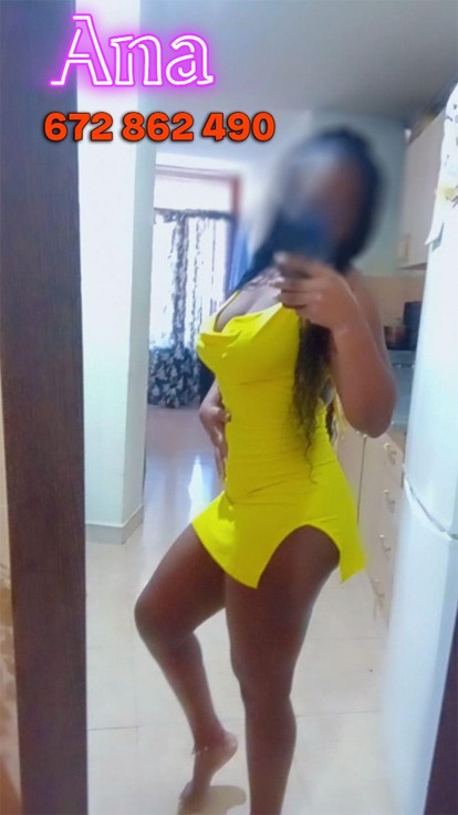 a woman in a yellow dress is taking a selfie