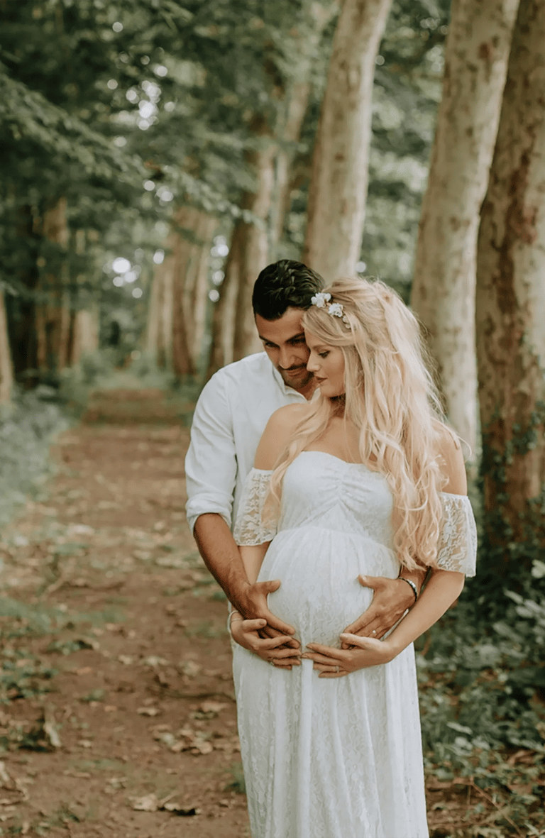 un couple dont la femme est enceinte pose pour une séance photo