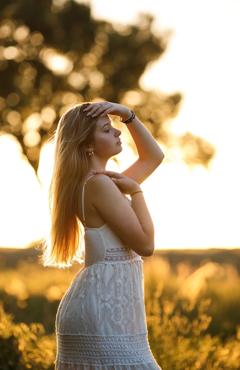 une jeune femme dans un champ au coucher du soleil