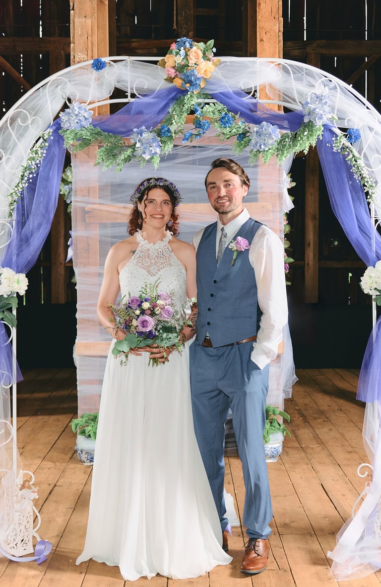 a groom and bride standing in front of a wedding arch