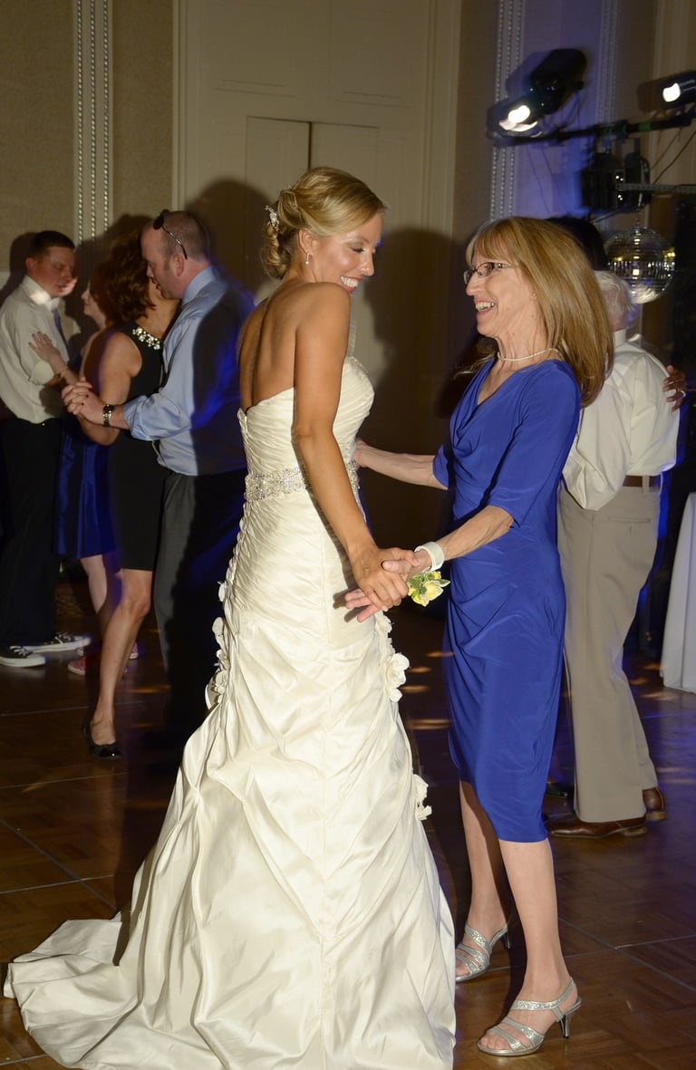 a bride and her mother dancing at a wedding in a hotel ball room