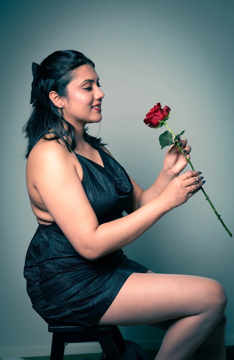 a woman in a black dress sitting on a stool