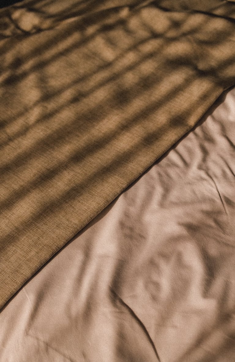 Bettdecke mit Licht und Schatten – Detailaufnahme Hotelzimmer