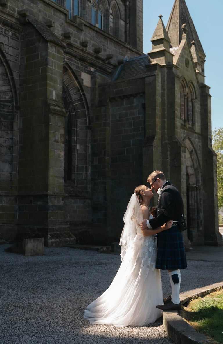 a bride and groom kissing in front of a church