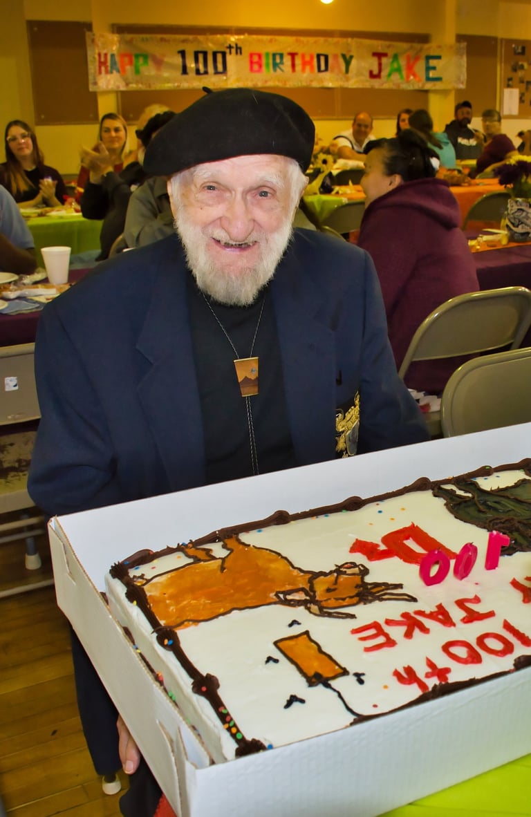 a man in a suit and hat with a cake in a birthday party