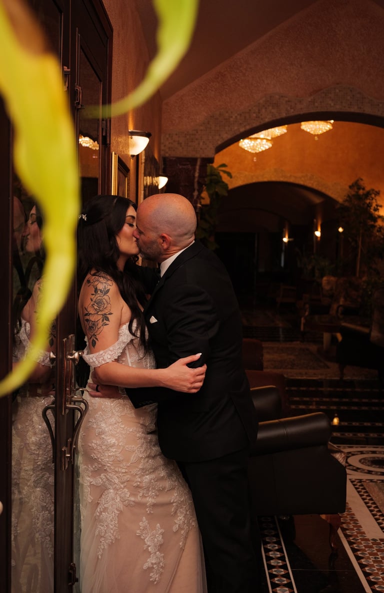 a wedding Couple kissing in a hotel lobby