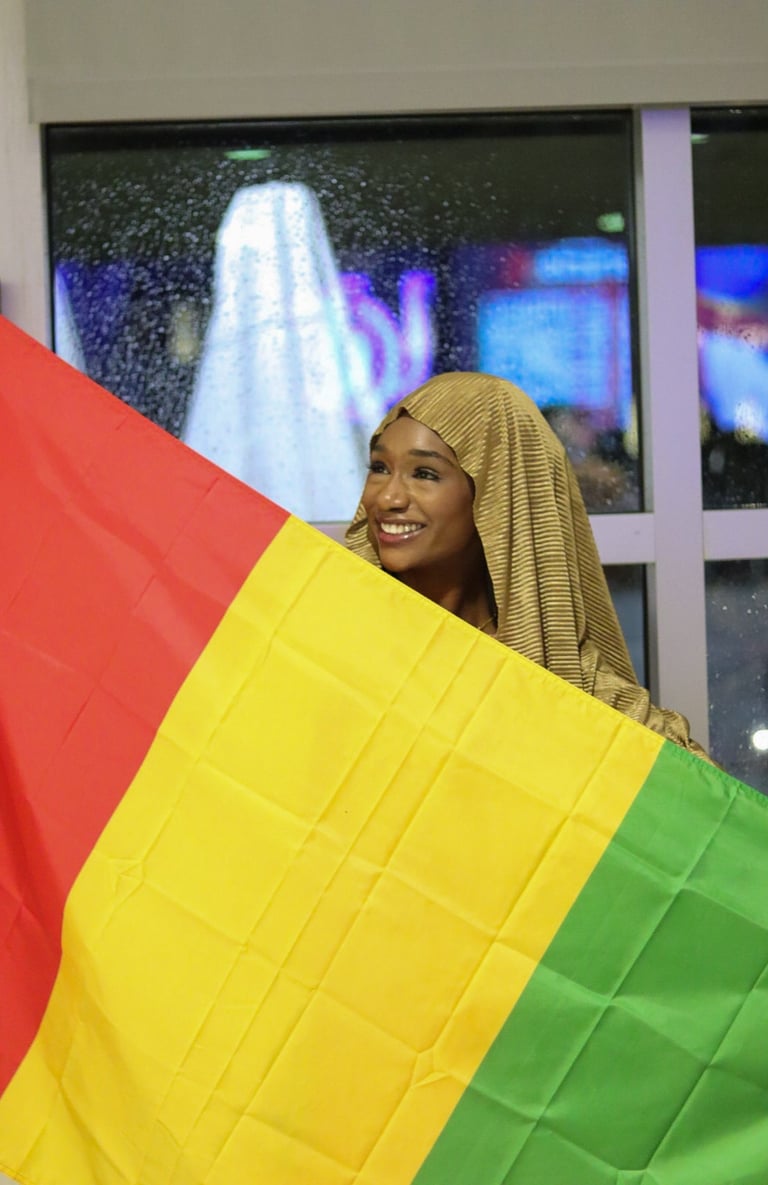 A woman holding a Guinea Flag for an event: Culture Show