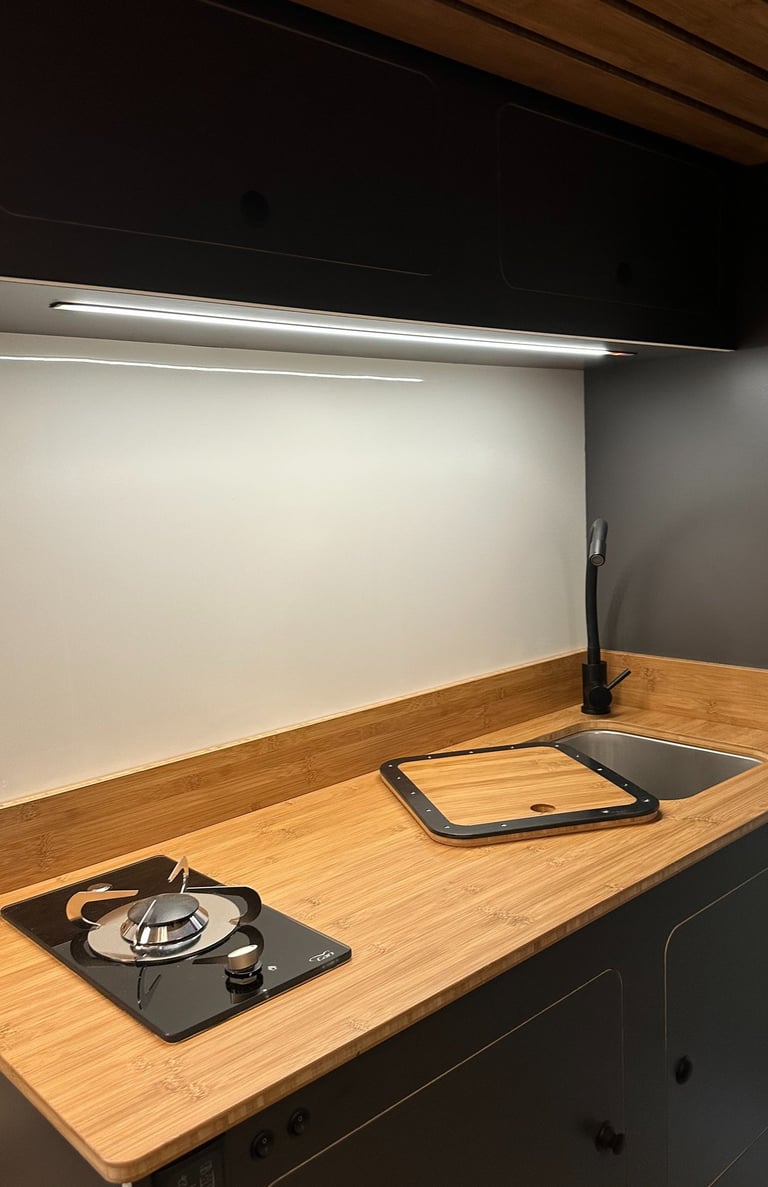 cocina interior de una célula camper con acabados de alta gama