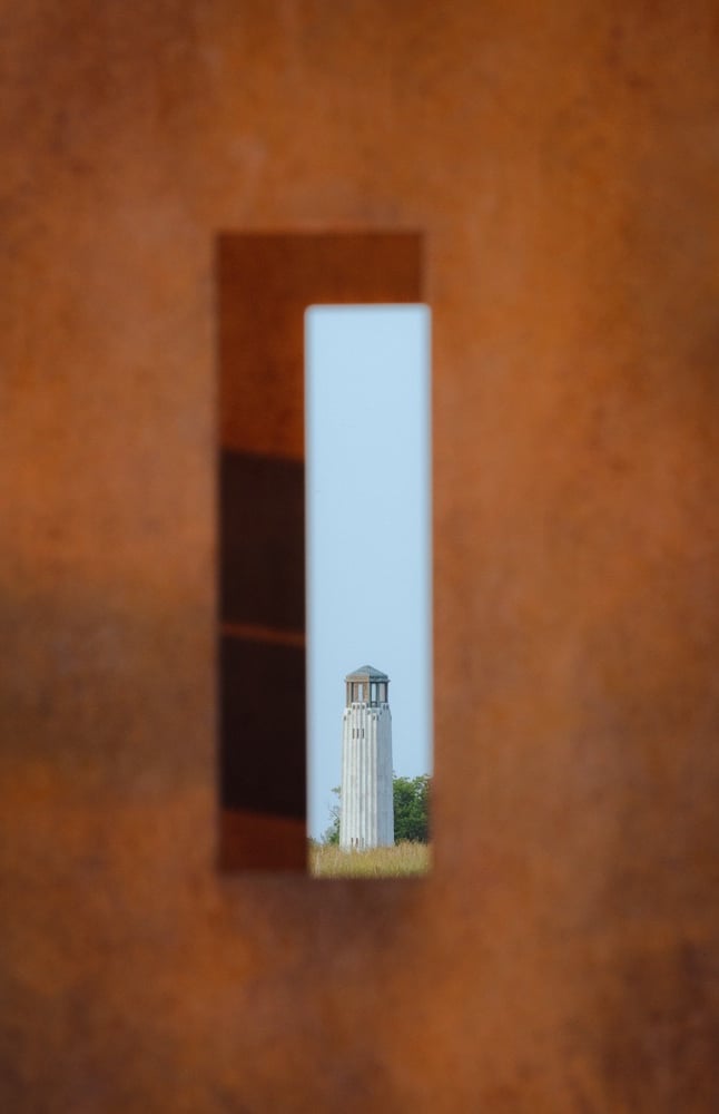 A lighthouse shot through an bronze urban sculpture. Framing looks cool.