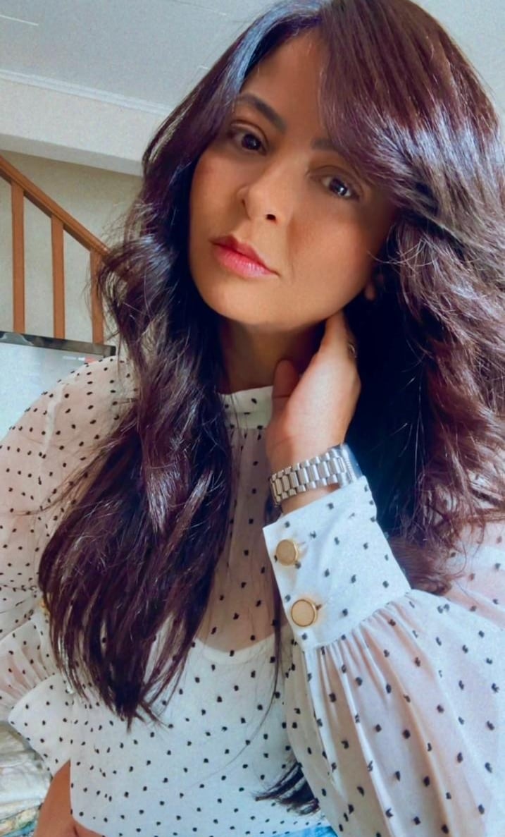 a woman with long hair and a polka dot shirt