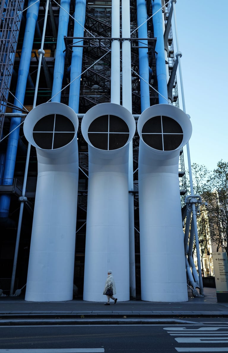 Pedestrian walking past three tall white vents on the façade of Centre Pompidou in Paris, By ACAT