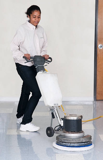 a woman is cleaning a floor with a floor cleaning machine