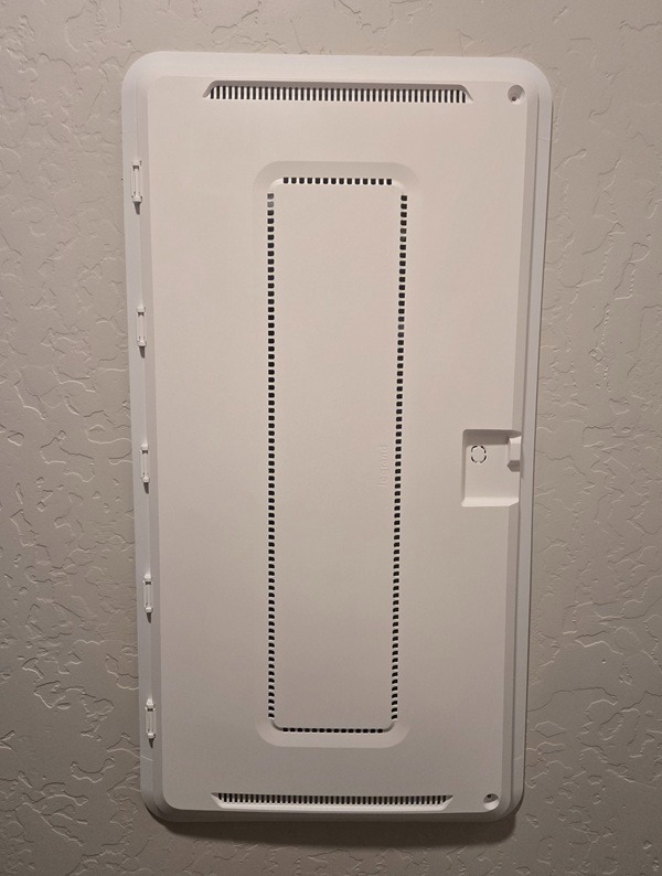 White Legrand structured media enclosure cover mounted on a textured wall for organized home networking.