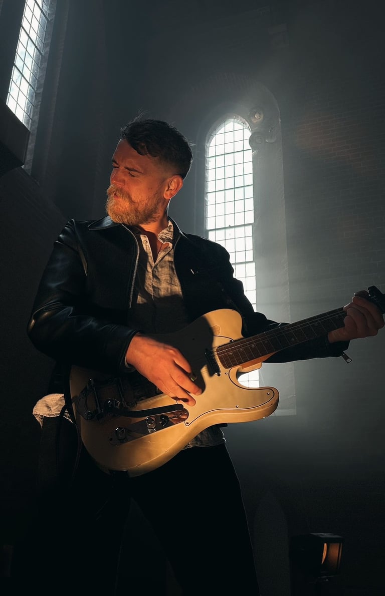 a man in a leather jacket playing guitar