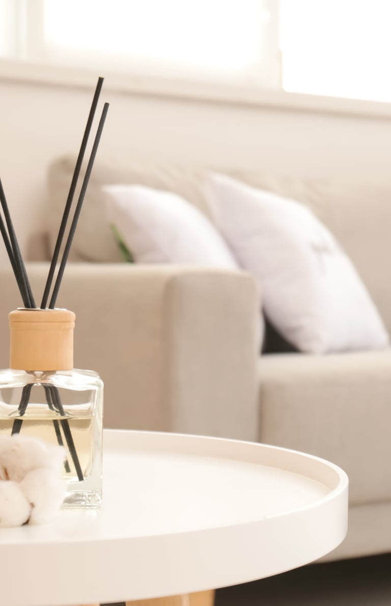 a table with a glass vase and a candle on it