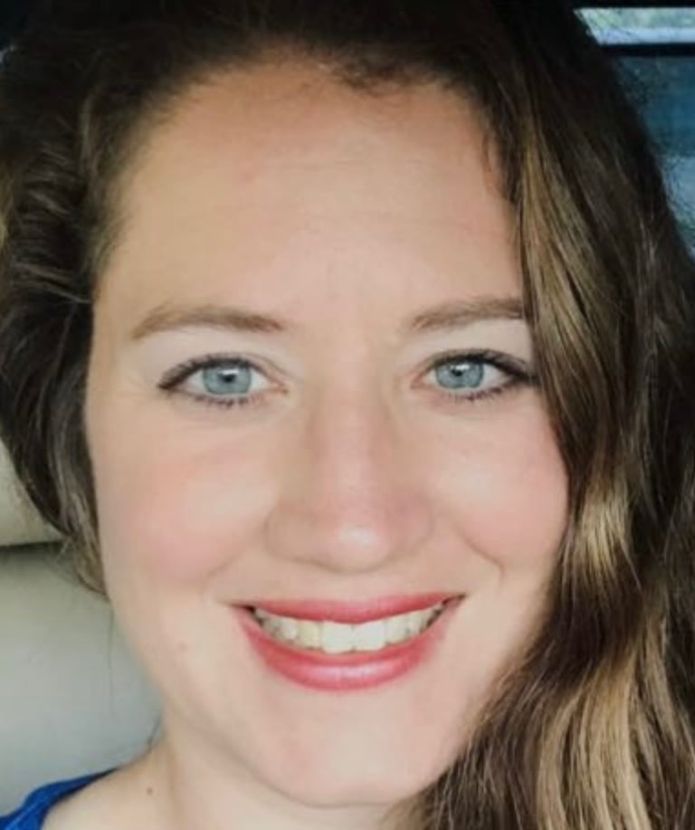 a woman with long hair and blue eyes and a blue shirt