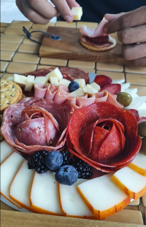 A beautifully crafted flower of salami and pepperoni on a gourmet charcuterie board featuring an ass