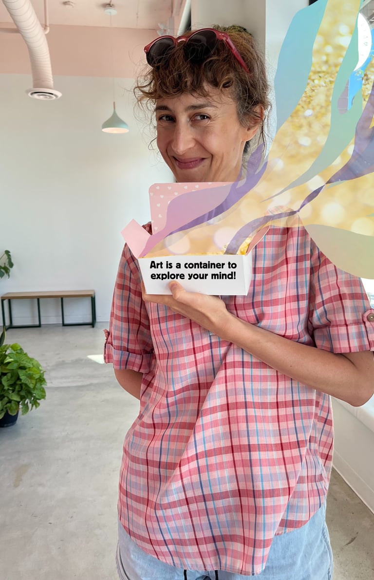 Lisa Cinar is smiling and holding a box that reads "Art is a container to explore your mind!"