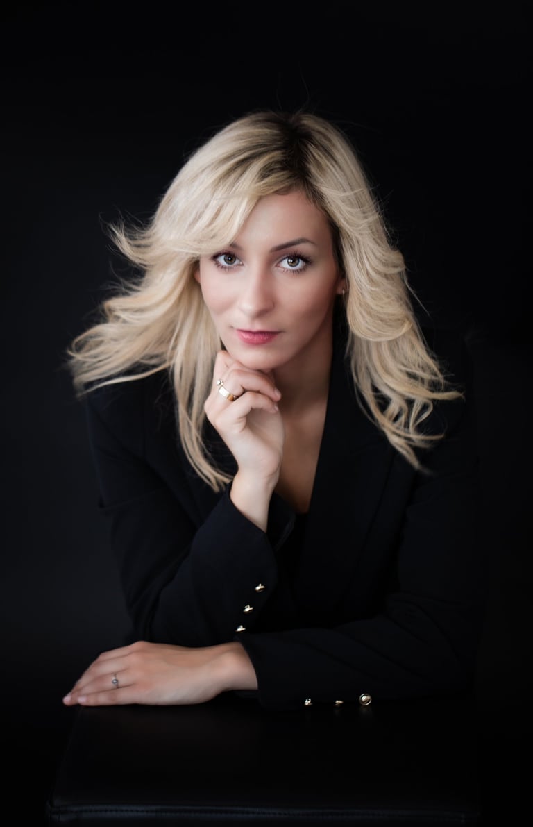 a portrait of a woman with blonde hair and a black jacket