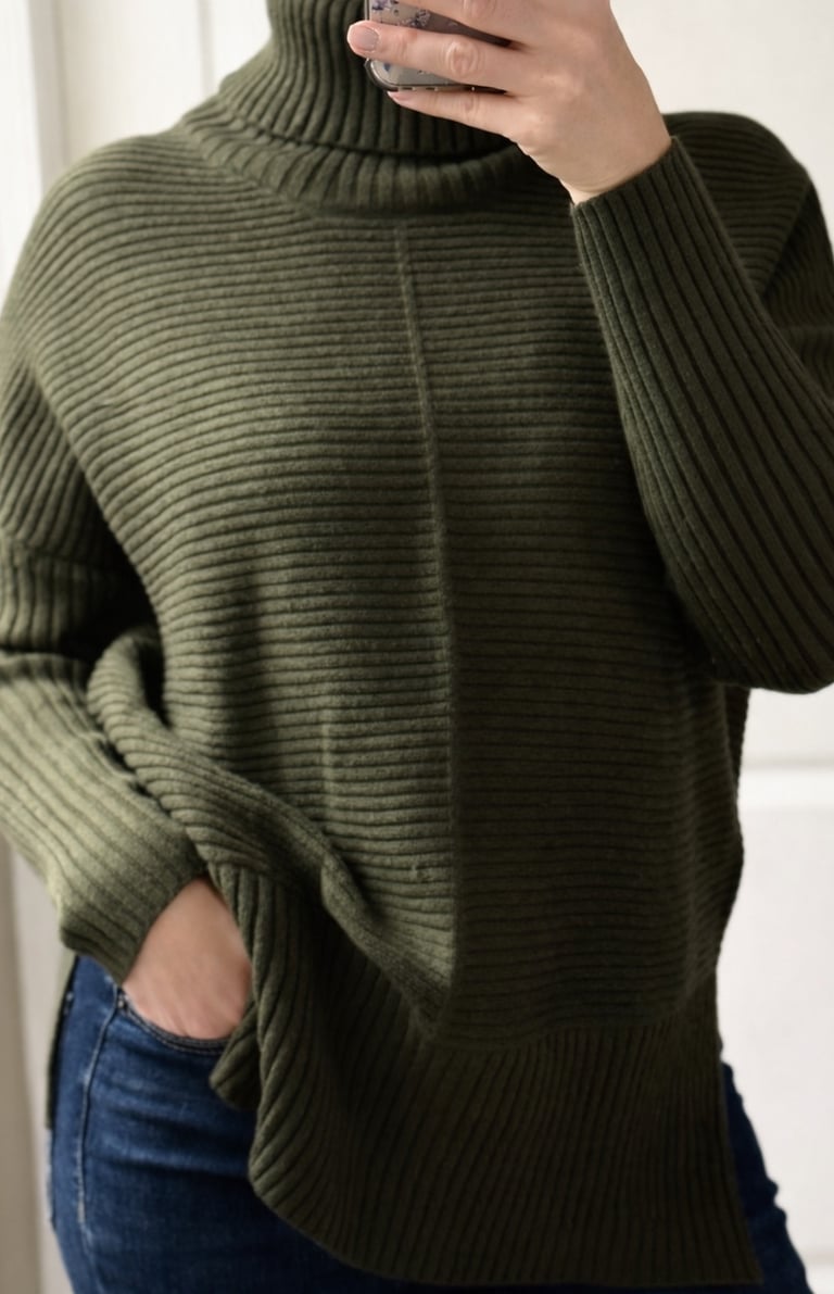 Close up of an army green ribbed turtleneck sweater styled with jeans for a casual outfit