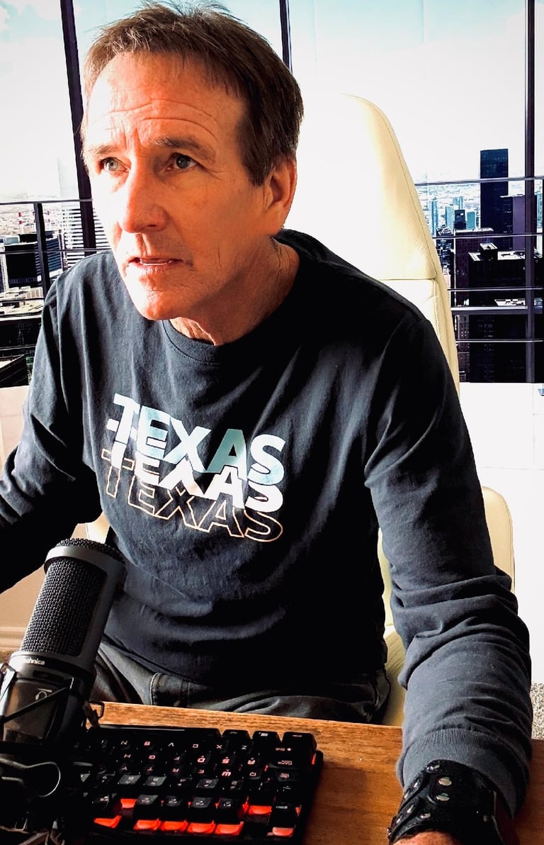Podcaster wearing a Texas shirt sitting at a desk with a microphone and gaming keyboard.