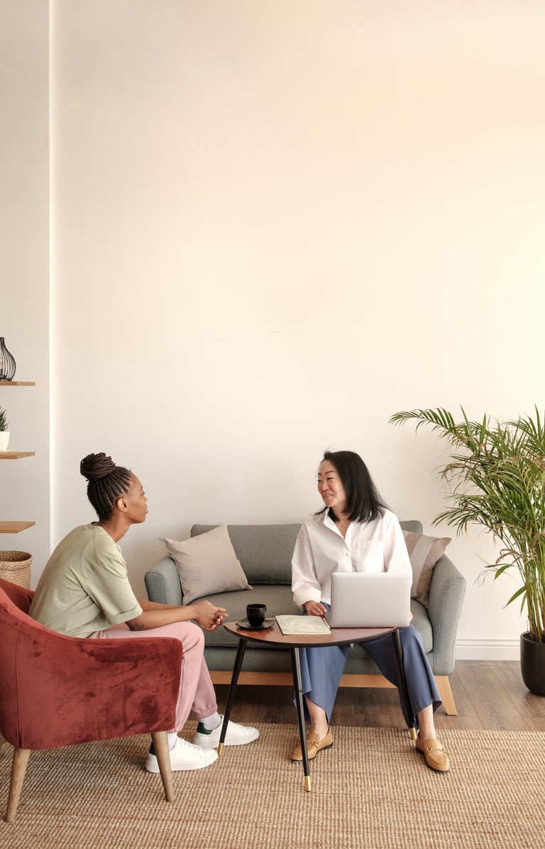 a woman sitting on a couch talking to a woman
