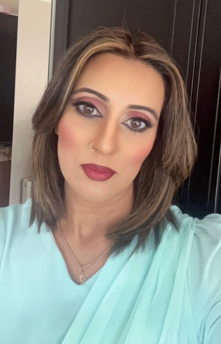 A woman with long brown hair smiles at the camera