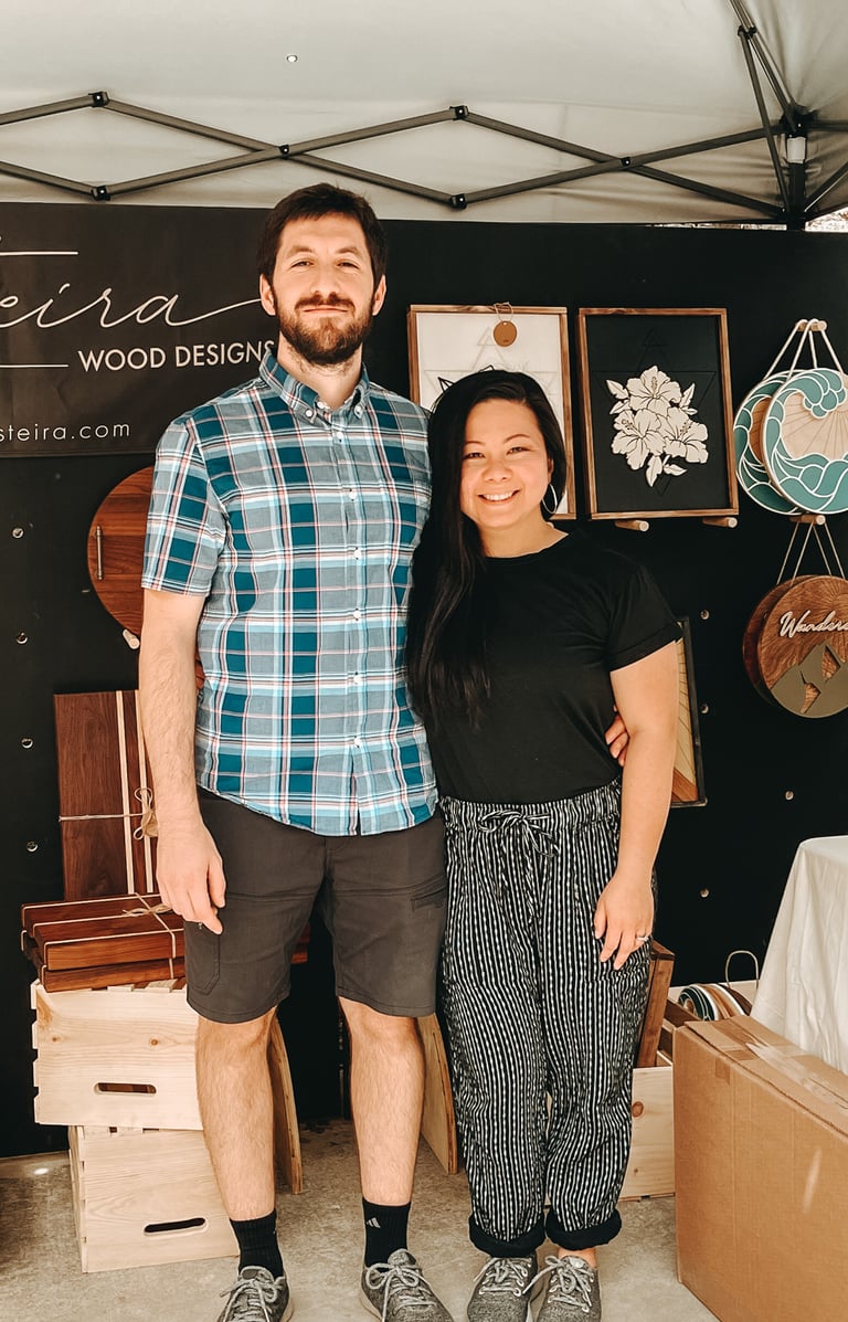 Gilliane and Victor, from Fusteira, at their booth, showcasing custom handcrafted wooden pieces.