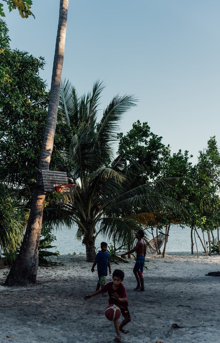 a group of people playing soccer on a sandy beach