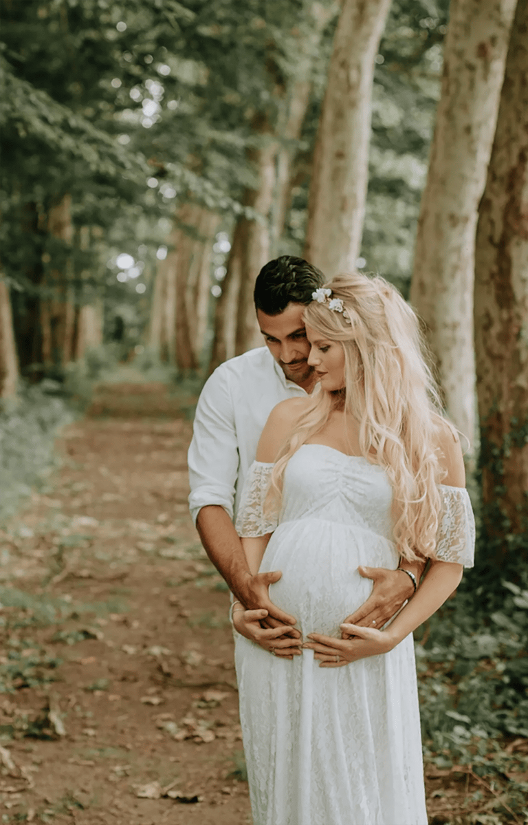 un couple dont la femme est enceinte pose pour une séance photo